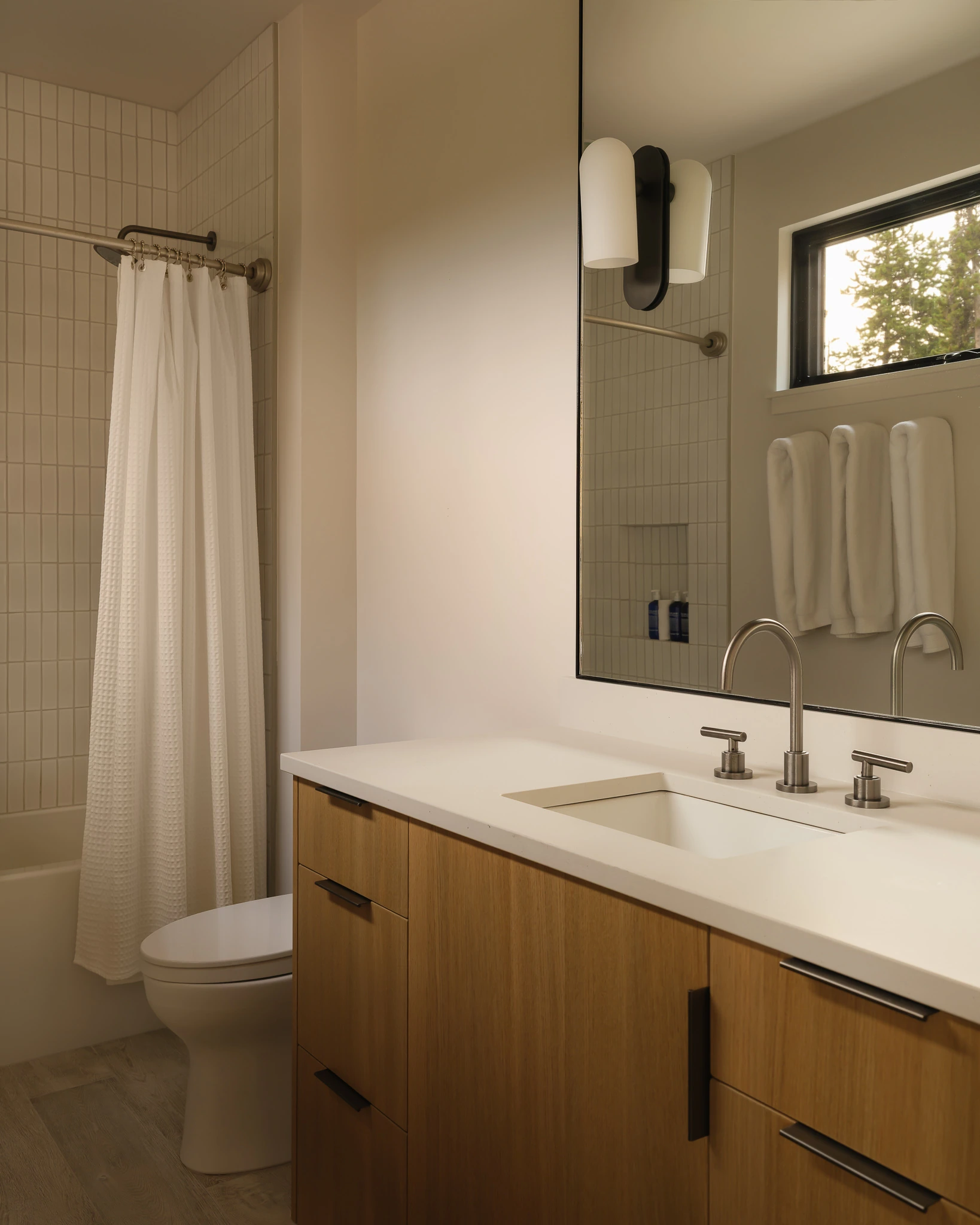 Bathroom with walnut vanity and walk-in shower — interior design photography Big Sky Montana, Speedwell Cabin